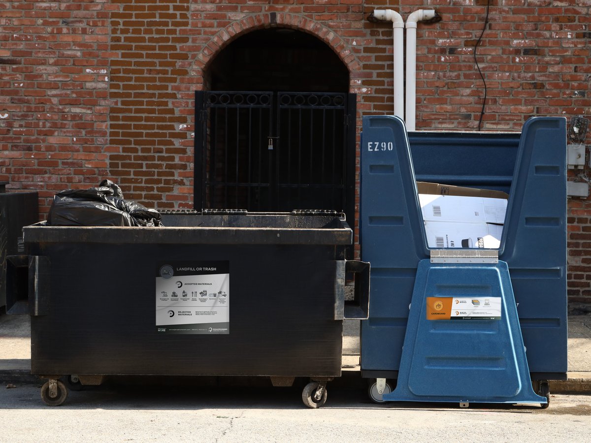 a dumpster and a crate full of cardboard