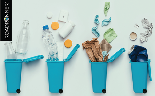 Four blue recycling bins with glass bottles, plastic bottles and lids, paper and cardboard, and aluminum cans.